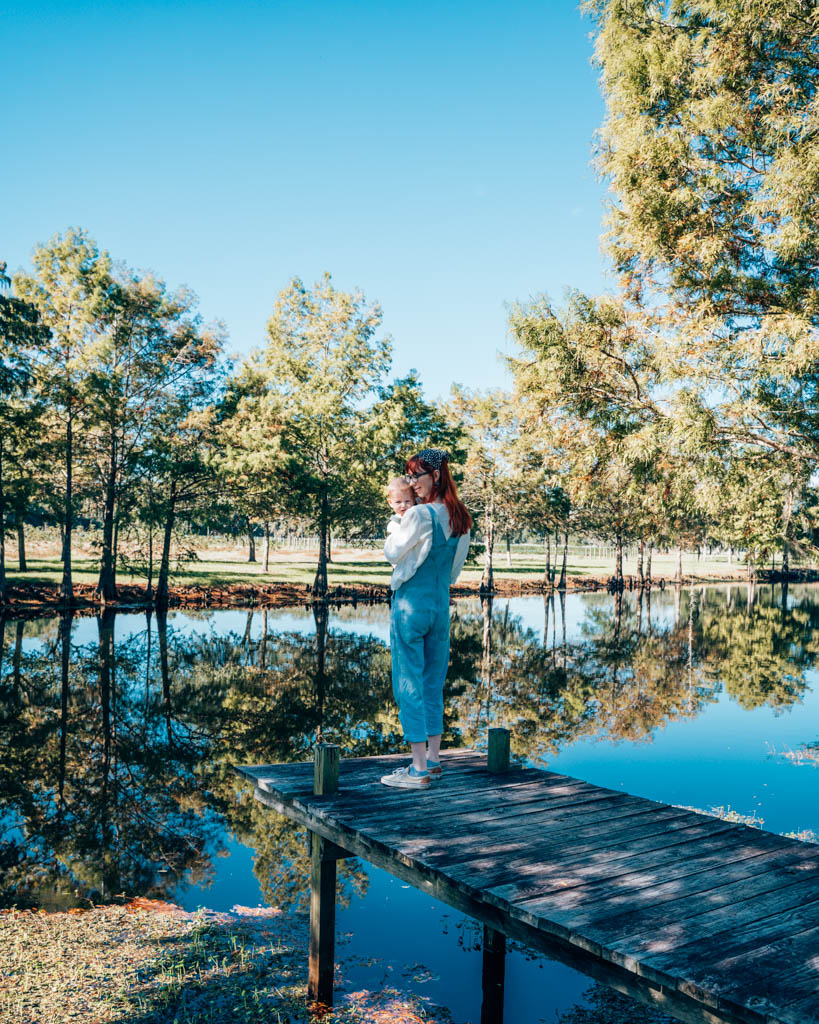 Standing near water with trees in background