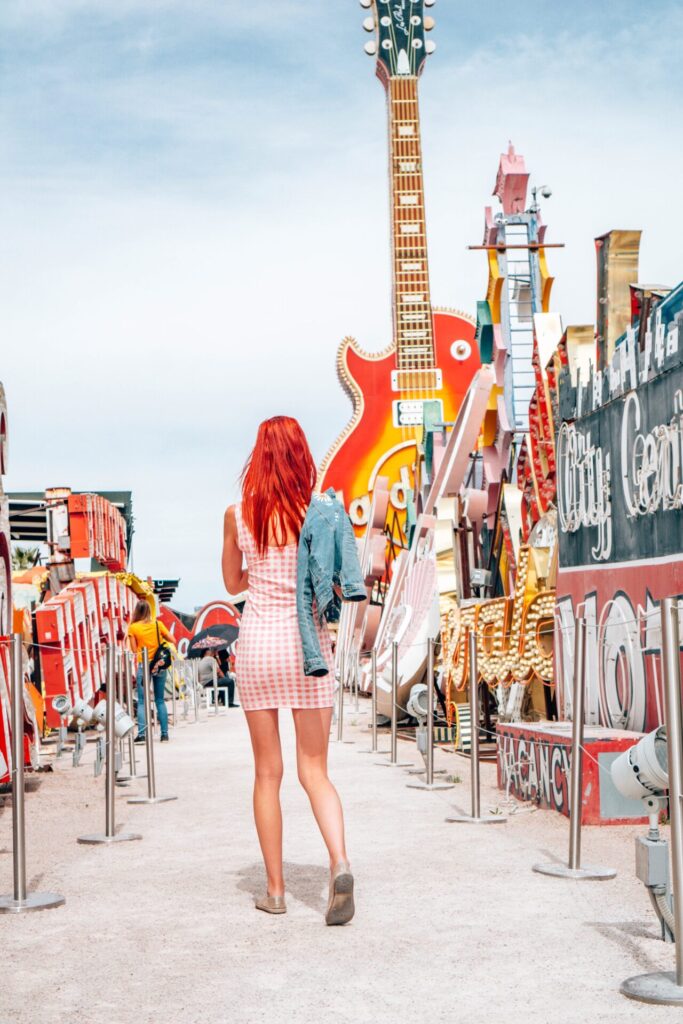 Neon Museum- girl standing in between old neon signs in The Boneyard at The Neon Museum 